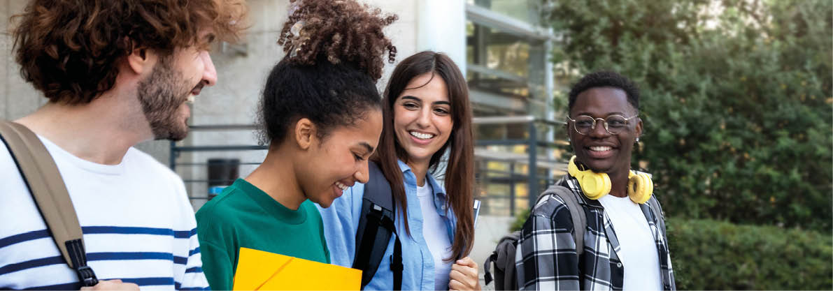 College friends walk to class together. Multiracial university students in campus talk and have fun outdoors.