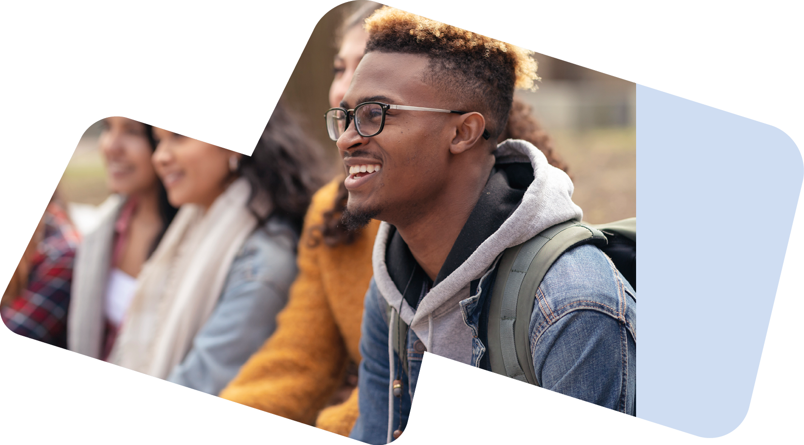 A middle-sized group of university-aged students, both male and female, are sitting outside on the campus grounds and relaxing before class. They are dressed in casual but stylish clothing while smiling.